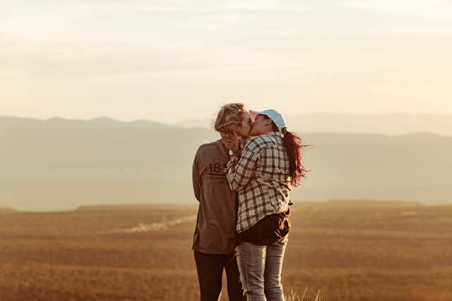 Imagen de una pareja que se besa en la montaña