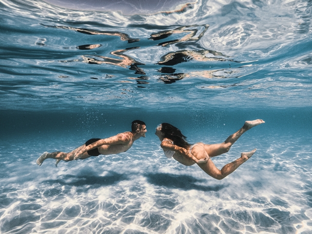 Imagen de una pareja nadando debajo del mar